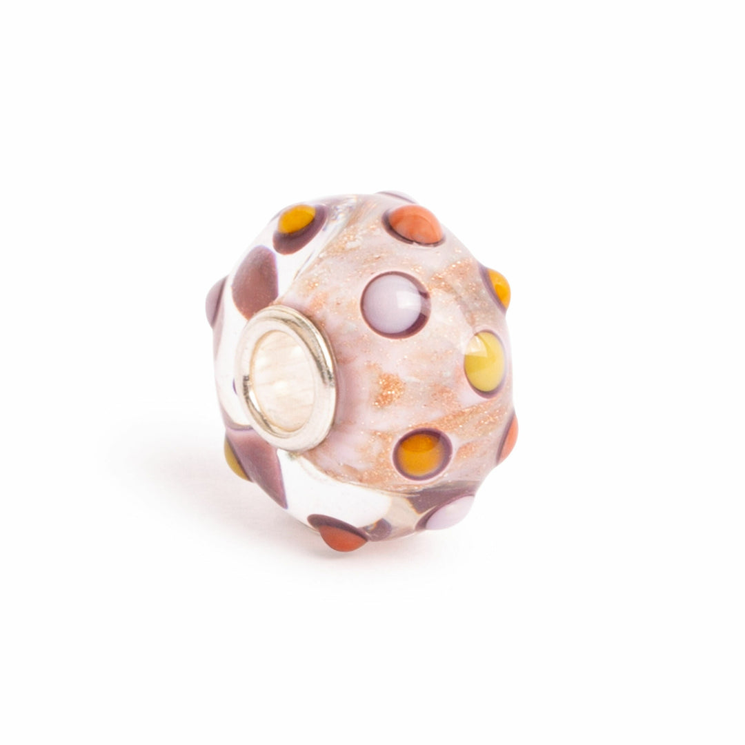 Decorative glass bead with multicolored dots on a white background
